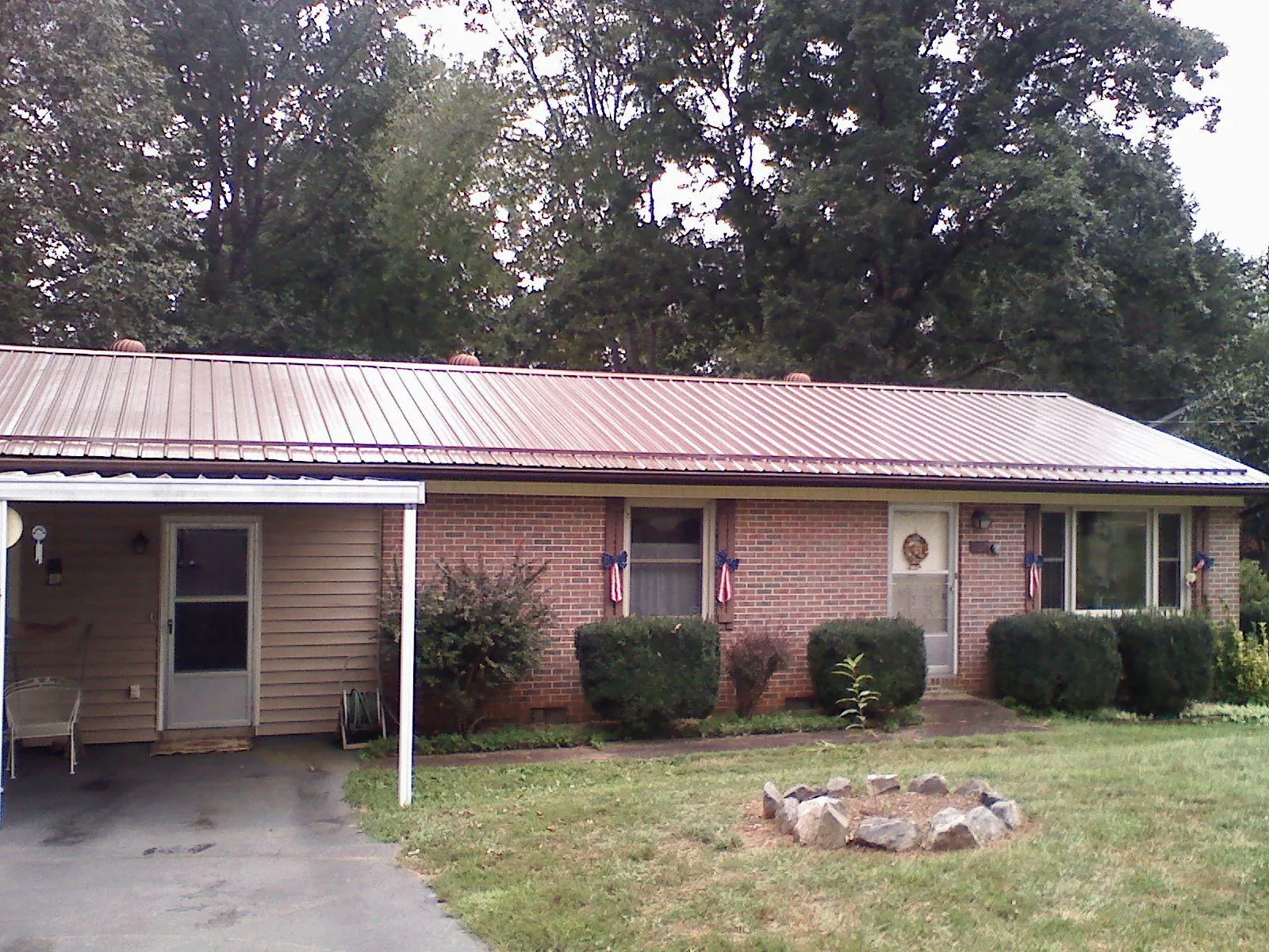 Bronze metal roof and carport on a brick ranch home — Roof Repair work by our crew in Port Saint Lucie